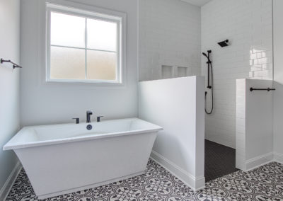 Modern bathroom with tiled walk-in shower and standing tub